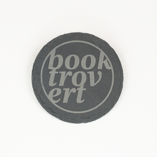 A round dark gray slate coaster with the words 'Booktrovert' printed in a light gray stylized font, centered on a plain white background.