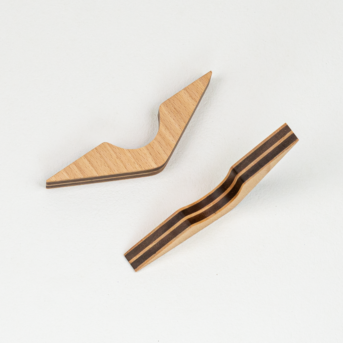Two v-shaped wooden page holders, one on its side and the other laying flat to show the various angles.