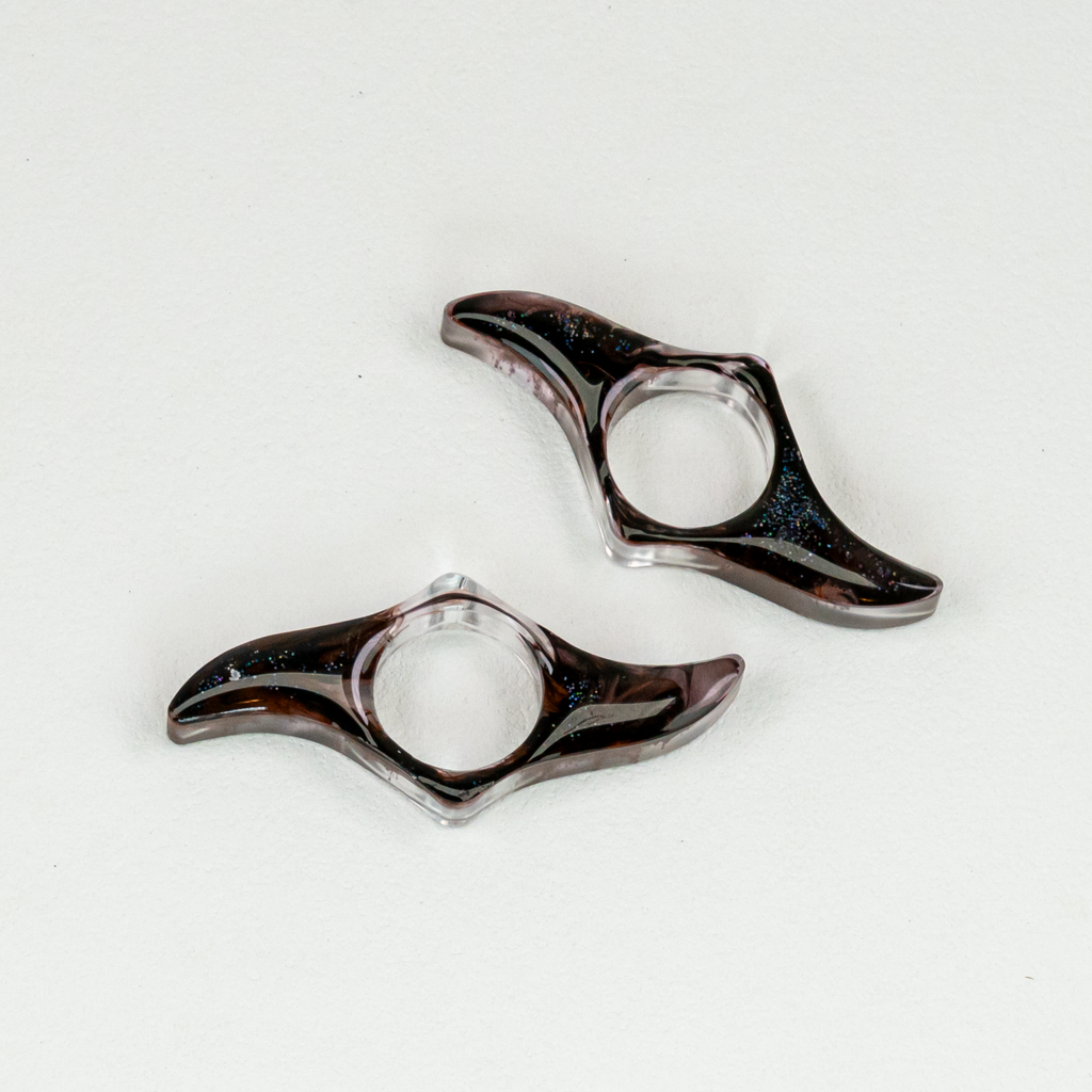 Two blades-shaped resin bookmarks with swirls of black and glitter.